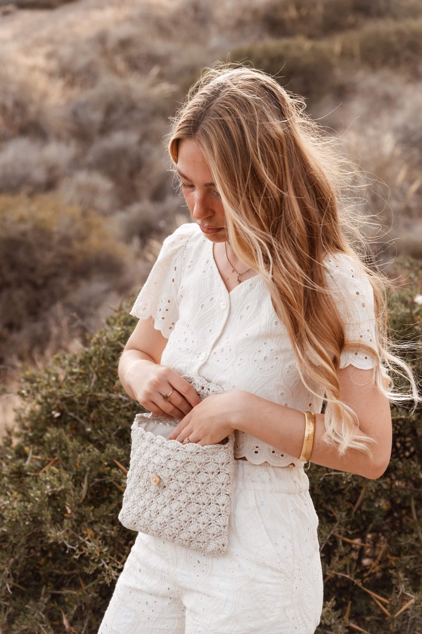 Mujer con neceser SALITRE de crochet, hecho a mano por Cabori en Almería, ideal para llevar imprescindibles con estilo.