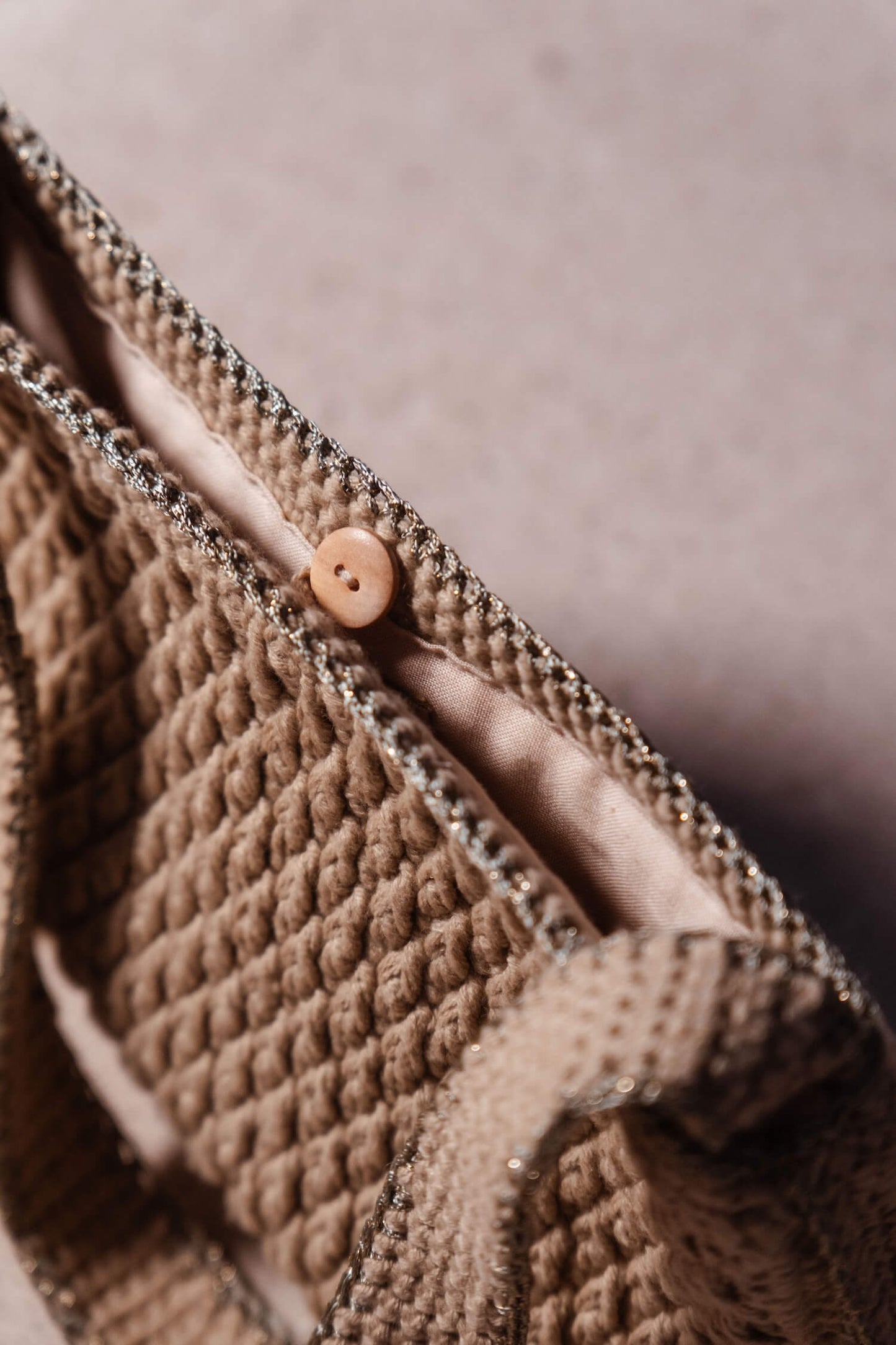 Plano cercano de bolso Pita de Cabori, hecho a mano en crochet color arena, con detalles en verde y dorado, estilo minimal versátil para cualquier ocasión.