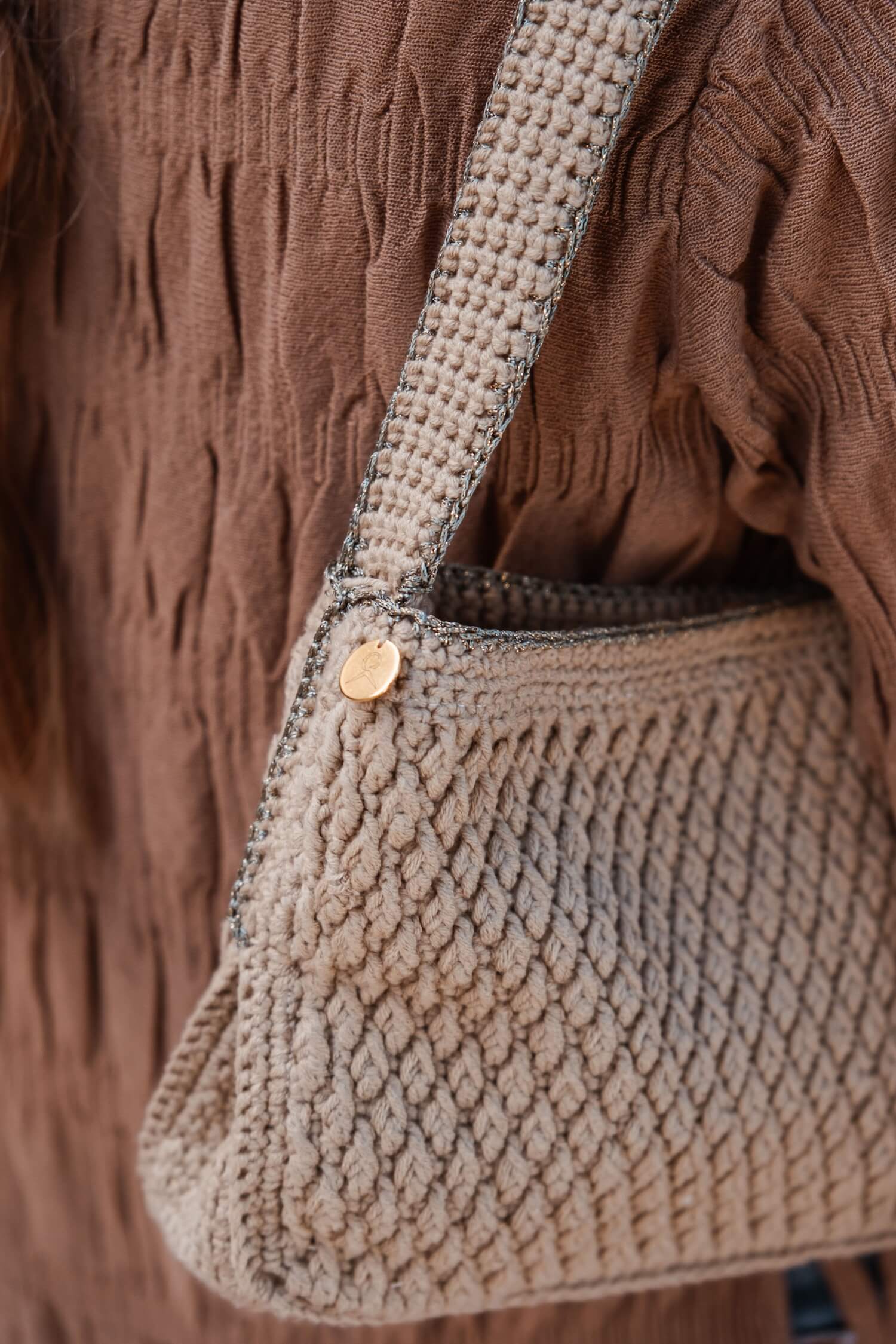 Detalle del bolso artesanal Pita de Cabori en crochet color arena, con borde en verde y dorado y diseño minimal mediterráneo.