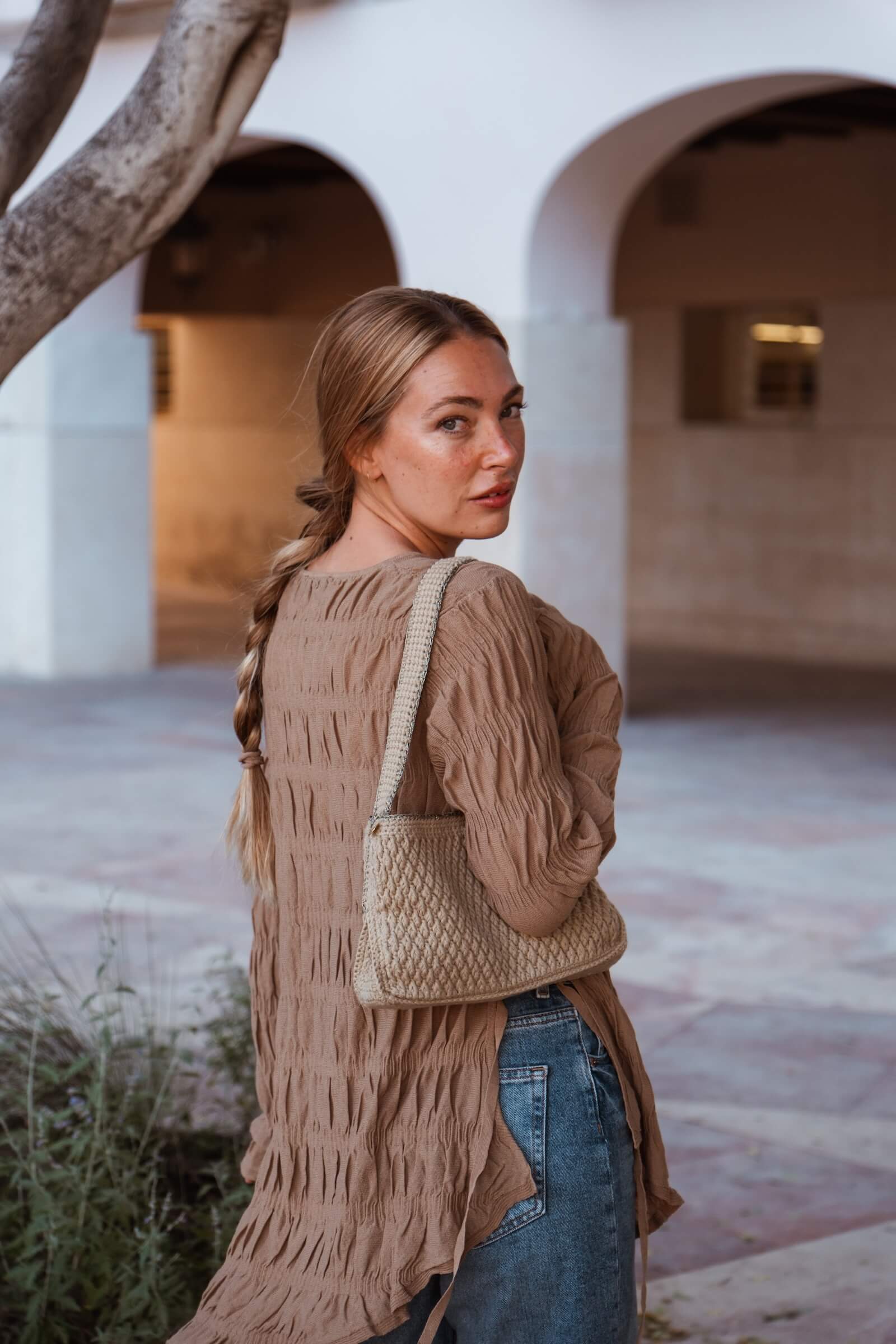 Mujer con bolso Pita de Cabori, color arena con diseño minimal artesanal hecho en España, complemento versátil para looks casuales y sofisticados.