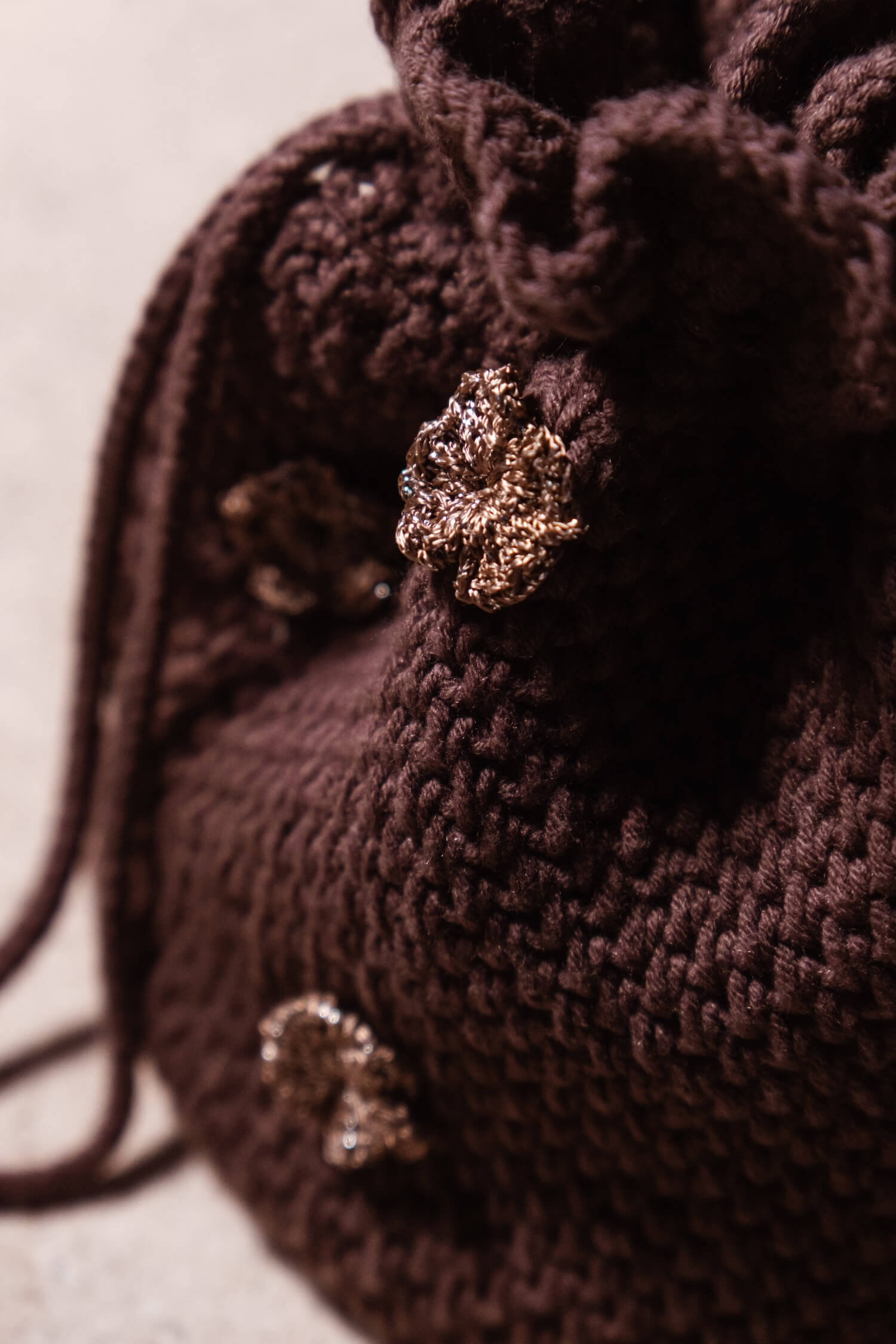 Detalle de apliques florales en crochet del bolso bombonera artesanal Cabori Cactus en color chocolate, hecho a mano en España.