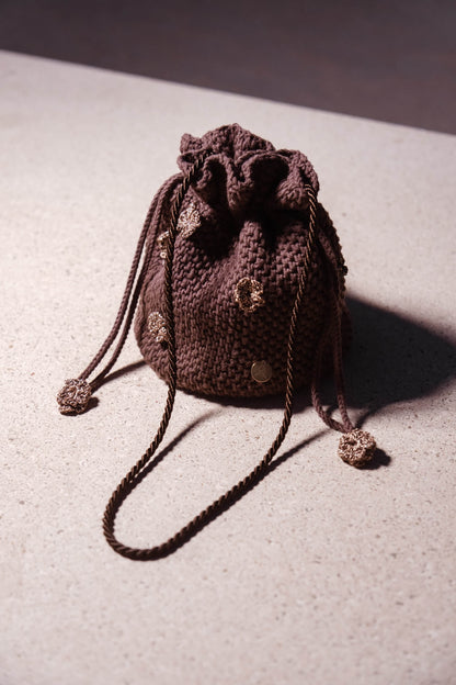 Bolso bombonera artesanal Cabori Cactus en crochet color chocolate con apliques florales y cierre de cordón, hecho a mano en Almería, ideal para invitada.